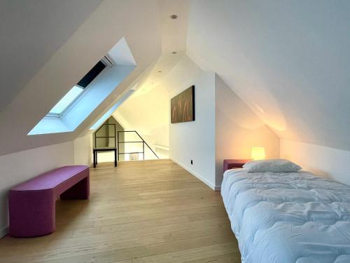 根特Exclusive Penthouse in Ghent的一间卧室配有一张床、长凳和天窗