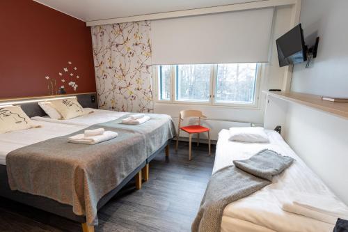 图尔库Hotel Linnasmäki的酒店客房设有两张床和窗户。