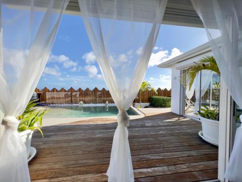 圣吕斯Villa Amaryllis luxueuse,piscine,vue mer,plage的一个带白色窗帘和游泳池的帐篷