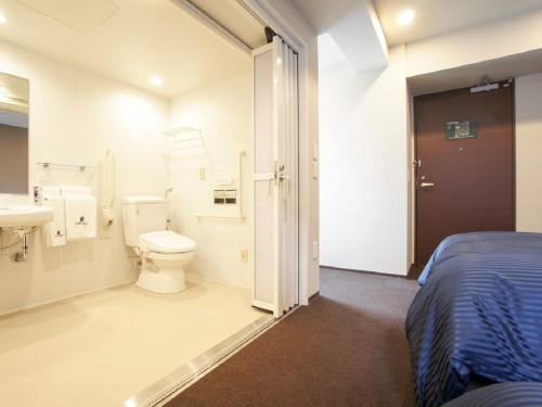 横滨HOTEL LiVEMAX Yokohama Motomachi Ekimae的浴室设有床、卫生间和水槽。