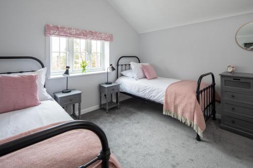 多切斯特Poacher's Cottage的一间卧室设有两张床和窗户。