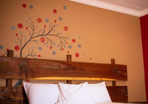 奥奇瓦龙戈MSC Hotel Otjiwarongo的卧室配有一张挂在墙上的树壁床。