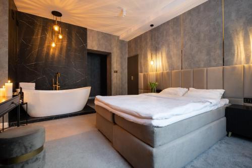 奥尔什丁Apartamenty Drewno i Ogień的一间卧室设有一张大床和一个浴缸
