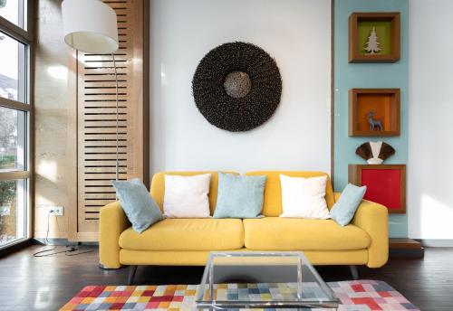 波恩numa I Bona Rooms & Apartments的客厅配有黄色的沙发和桌子