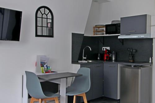 杜埃Location Tame的厨房配有桌子、两把椅子和台面