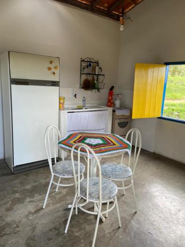卡兰卡斯Chalé Boa Vista的厨房配有桌椅和冰箱。