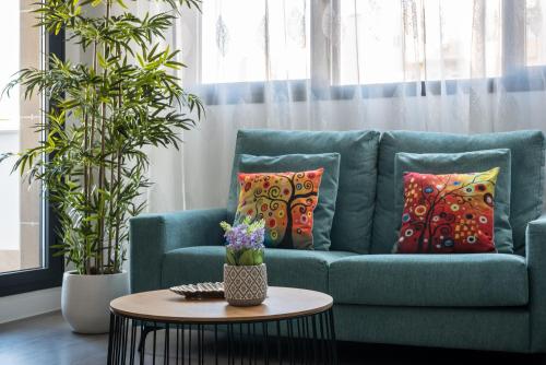 EsteponaApartamento Estepona II的客厅配有带枕头和桌子的蓝色沙发