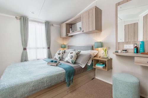 米尔福德昂西56 Seabreeze的一间小卧室,配有床和蓝色凳子