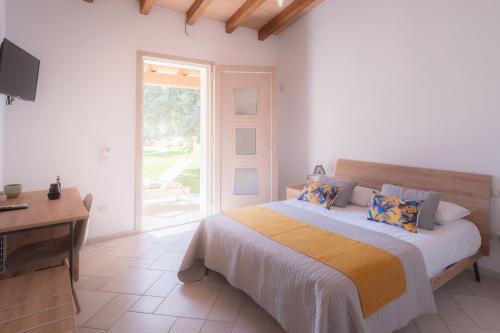 San GiorgioSu Cappeddu Agriturismo的一间卧室配有一张床、一张书桌和一个窗户。