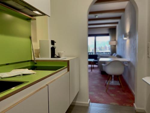 巴特维塞Sonnhof Apartments Tegernsee - zentral und perfekt für Urlaub & Arbeit的厨房配有绿色台面和书桌