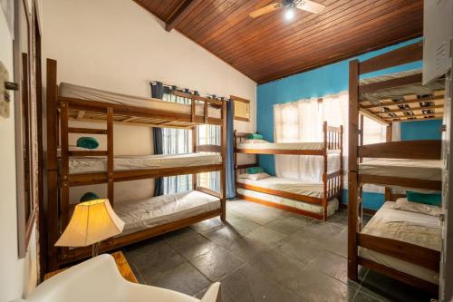 阿布拉奥Hostel Papagaio的带三张双层床和一盏灯的房间
