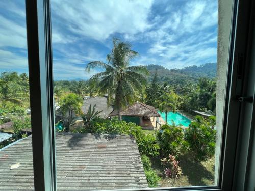 蔻立RT KhaoLak Hotel的从带游泳池的度假村窗户欣赏美景