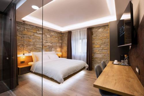 科佩尔Štok - Rooms, Wine & Restaurant - Marezige, Koper的一间卧室配有一张床、一张木桌和一张餐桌。