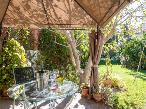 卡莱塔德贝莱斯Villa Mara by Interhome的花园帐篷下的玻璃桌