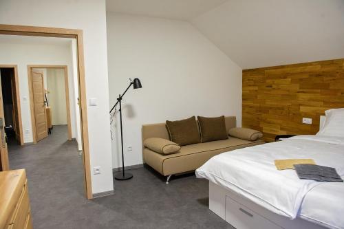 耶塞尼克Chalupy Slunná的一间卧室配有床、沙发和灯