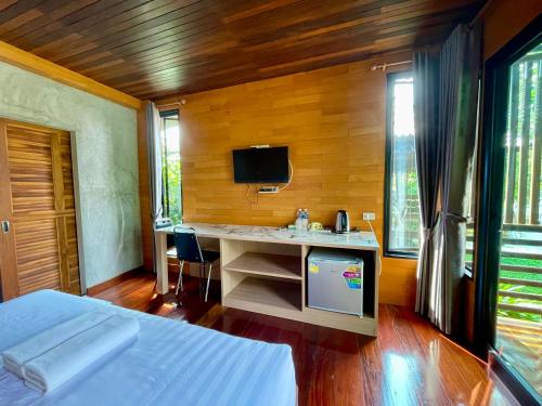 Ban Bang Khamเพชรพิชชารีสอร์ท的一间卧室配有一张床和一张书桌及电视