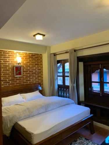 加德满都Studio Apartment at UNESCO Heritage Site的一间卧室设有一张床和砖墙