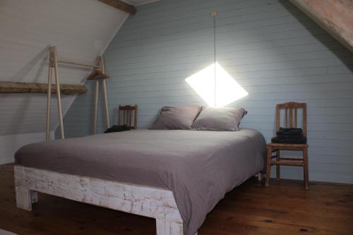 't Jongehof的一间卧室配有一张床,上面有灯