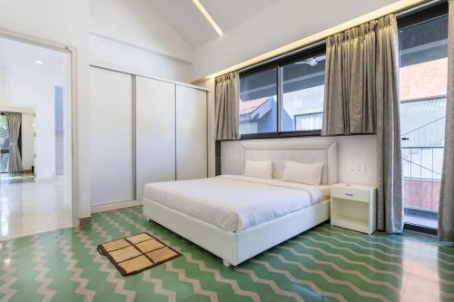 果阿旧城Luxury 3BHK Villa with Private Pool near Anjuna的卧室设有白色的床和大窗户
