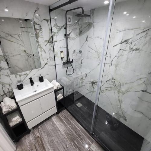 卡帕里卡海岸Nandos Apartement的一间带大理石淋浴和盥洗盆的浴室