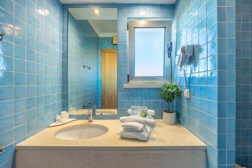 萨格里什蓬塔雷亚度假公寓的蓝色瓷砖浴室设有水槽和窗户