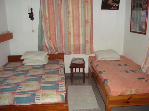 格兰贝伊Souriam Villa的客房设有两张床、一张桌子和一扇窗户。