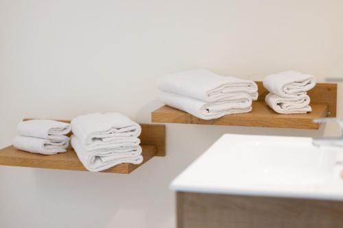 亚斯凯恩Hotel Residence Alaïa的浴室里木架上的毛巾堆