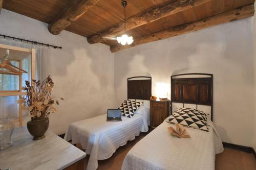 Coreglia AntelminelliLa Casetta的一间卧室配有两张床和一张桌子上的笔记本电脑
