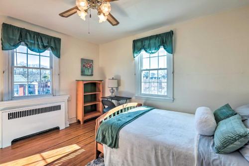 Drexel HillYeadon Townhome with Porch, 7 Mi to Center City的一间卧室设有一张床和两个窗户。