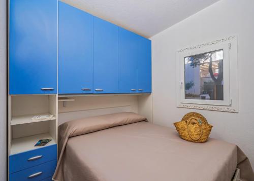 圣塔马里亚迪卡斯特Villaggio Leucosia的一间设有蓝色橱柜和一张床的小卧室