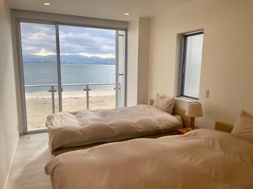 福冈Luxury Villa Saitozaki UMIHOTARU的海滩景客房 - 带两张床