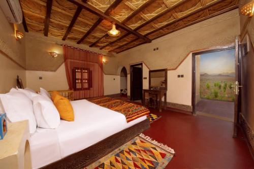 瓦尔扎扎特Ecolodge l'île de Ouarzazate的一间卧室设有一张床和一个大窗户