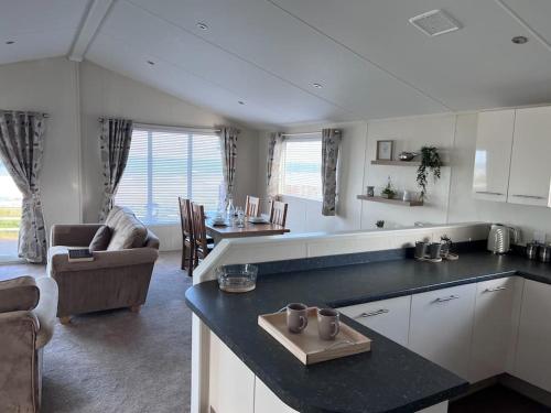 哈特尔普尔Beautiful 2-Bedroom Lodge with Spectacular Views的厨房以及带沙发和桌子的客厅。