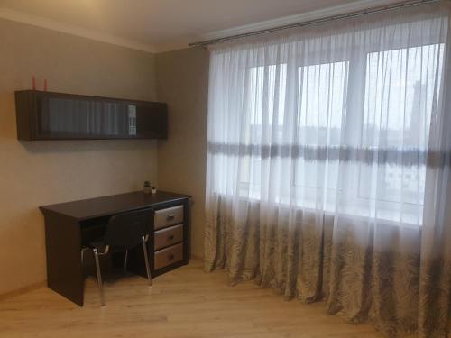 文尼察Apartament Vasilya Porika 48 Street Vinnitsya的一间卧室配有书桌和窗帘的窗户