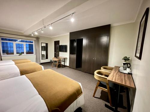 库斯科CASA MONTES PARDO的酒店客房配有两张床和一张书桌