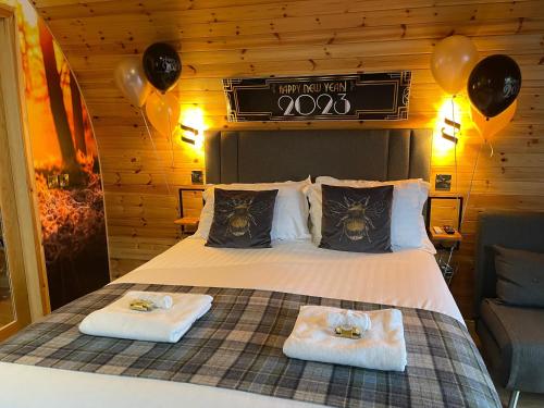 基斯高地2 Sinclair bay lodges的一间卧室配有一张带两条毛巾和气球的床。