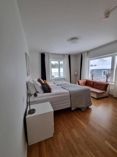 东哈尔马Gamla Järnhandeln - Norrskedika Hotell的白色卧室配有床和沙发