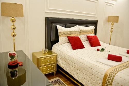 图兹拉Luxury Apartment Karic FREE parking的一间卧室配有红色枕头的床