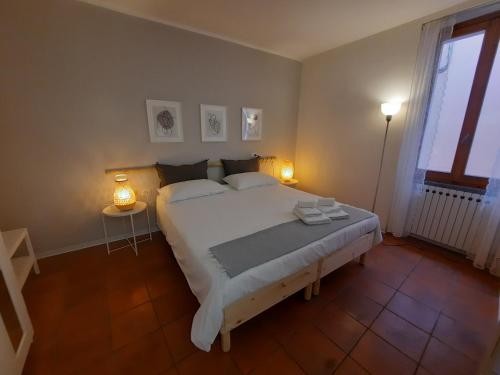 安杰拉Contrada d'Amore的一间卧室配有一张带两盏灯的大型白色床。
