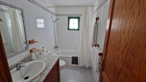 阿列塔Chelada的白色的浴室设有水槽和浴缸。