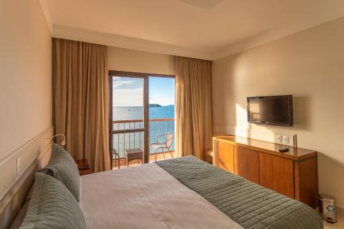 弗洛里亚诺波利斯Jurerê Beach Village - OFICIAL的酒店客房设有床、电视和阳台。