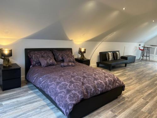 BritishGreen Monkey Lodge的一间卧室配有一张大紫色的床和一把椅子