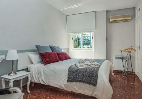 塞维利亚Apartamento New Folch Sevilla A的一间卧室配有一张带红色和蓝色枕头的床
