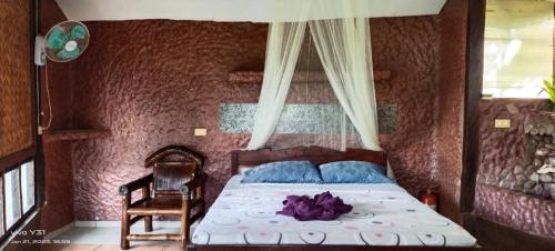 公主港Bambua Nature Cottages的一间卧室,床上有紫色鲜花