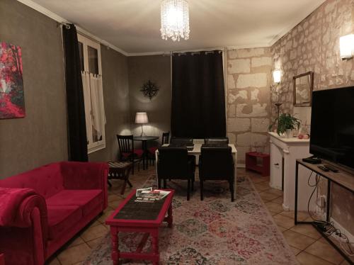 希农La Boussole - Maison meublée 3 chambres 6 pers.的客厅配有红色的沙发和桌子