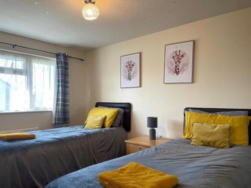 莱奇沃思Comfy Letchworth Apartment by Leecroft Stays的一间卧室配有两张带黄色枕头的床