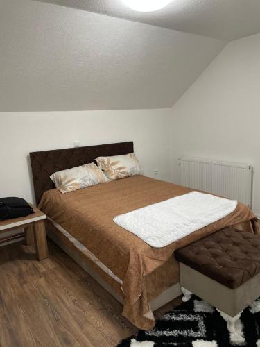 KalesijaApartman ALMA的一间卧室配有一张带棕色棉被的床