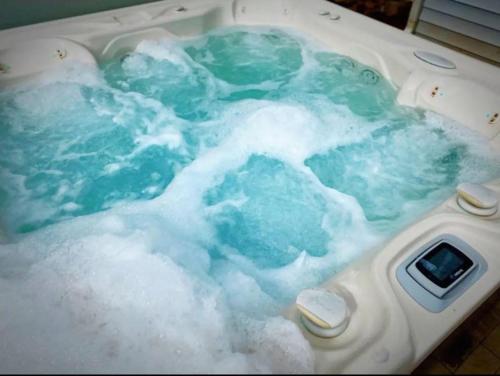 夏洛特Stylish 4B 3B -King Bed- Jacuzzi的浴缸装满蓝色的泡沫水