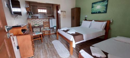阿拉亚尔-杜卡布Estúdio Recanto Dos Anjos的小客房设有带一张床和一张书桌的卧室