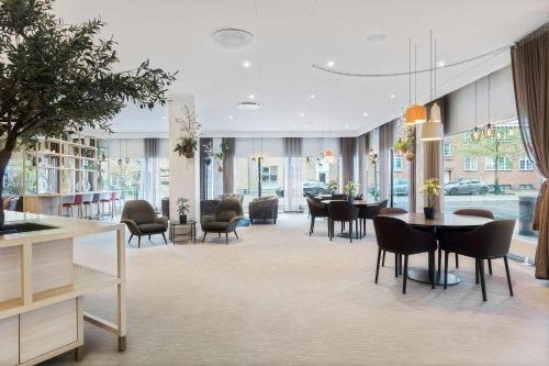 哥本哈根Best Western Plus Airport Hotel的一个带桌椅的用餐室和一个图书馆